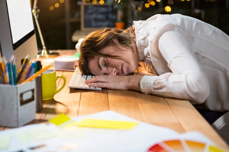 Tired businesswoman sleeping on the desk in the office.jpeg
